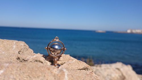 Surface level view of metal object against calm beach