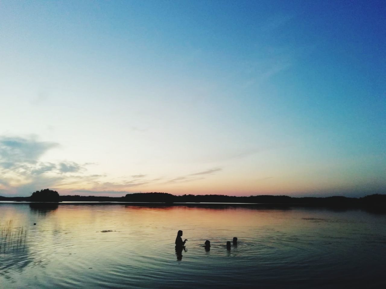 sky, water, beauty in nature, scenics - nature, silhouette, waterfront, tranquility, group of people, tranquil scene, lake, reflection, nature, sunset, swimming, idyllic, real people, copy space, unrecognizable person, leisure activity, outdoors