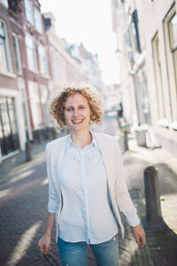 Smiling woman standing on street in city