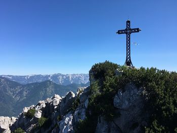 Cross in temple against clear blue sky
