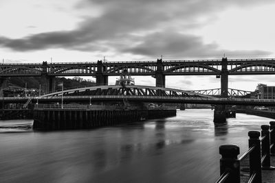 Bridge over river against cloudy sky