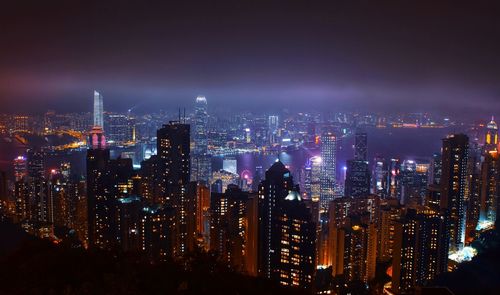 High angle view of illuminated buildings against sky at night