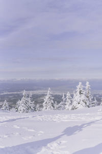 Snow covered landscape against sky