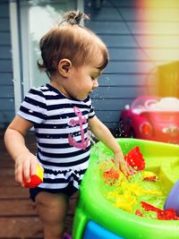 Cute girl looking away while playing with toys 