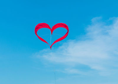 Low angle view of red wall against blue sky