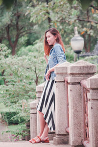 Woman smiling while standing against trees