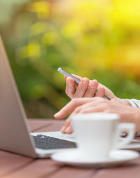 Cropped hands using mobile phone