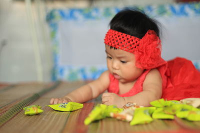 Cute baby girl sitting on table at home