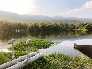 Scenic view of lake by mountains against sky