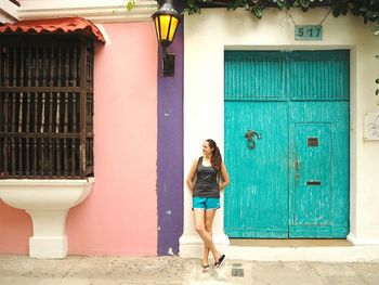 Full length of woman standing against building