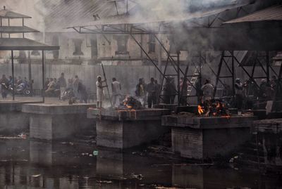 People by buildings against river