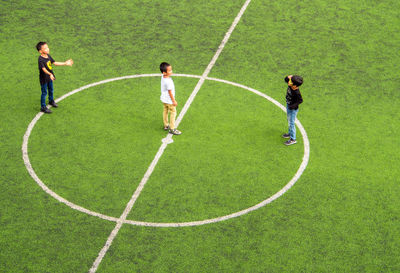 High angle view of two men standing on green grass