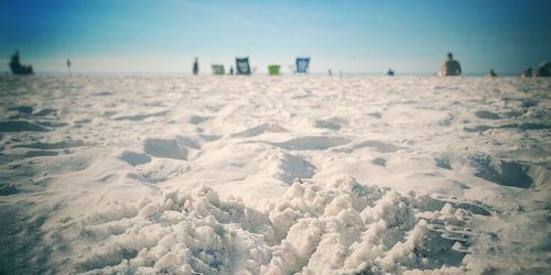 Surface level of sandy beach against clear sky