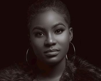 Close-up portrait of a beautiful young woman over black background