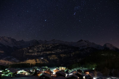 Scenic view of illuminated mountains against sky at night