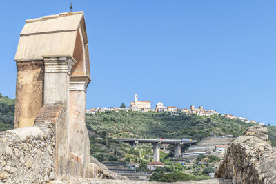 The ancient roman bridge in taggia with castellaro in background