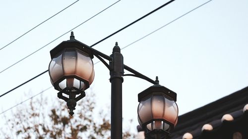 Low angle view of illuminated street light against sky