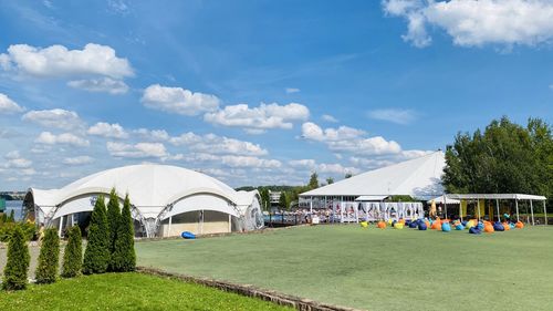 People in park by field against sky