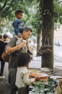 Father with son and daughter doing shopping at flea market