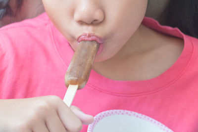 Asian little girl eating ice cream stick