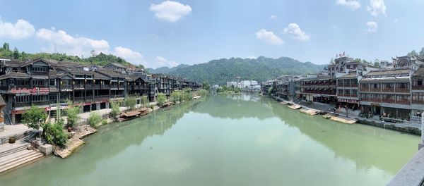 Panoramic view of canal amidst buildings against sky