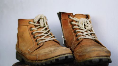 Close-up of old shoes against gray background