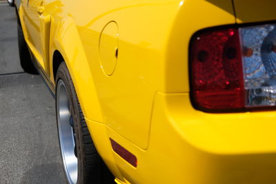 Close-up of yellow car on street