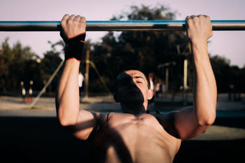 Shirtless man exercising at park