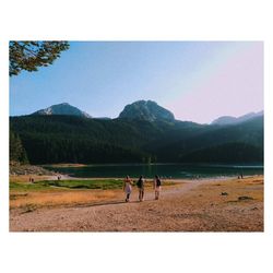 People on mountain against clear sky