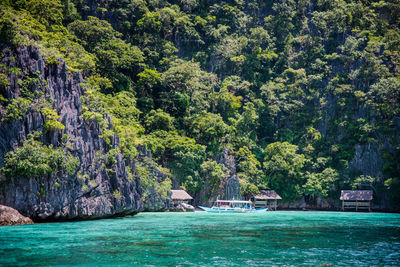 Private cottages in white sand beach with majestic limestone wall in the back.