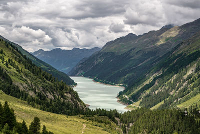 Scenic view of river amidst mountains against sky