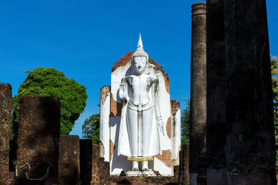 Panoramic view of statue amidst buildings against sky