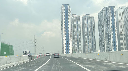 Road amidst buildings against sky in city