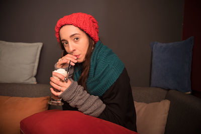 Close-up of young woman drinking water from sofa