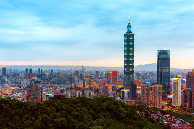 Buildings in city against cloudy sky