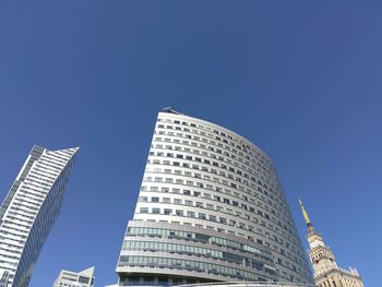 Low angle view of modern buildings against blue sky