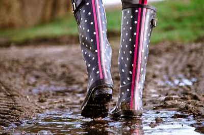 Low section of woman walking on dirt road