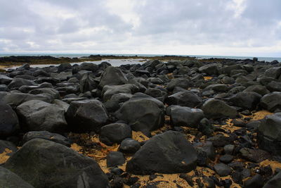 Rocks on beach against sky