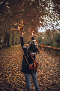 Rear view of woman with umbrella during autumn