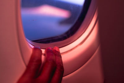 Close-up of hand on airplane window