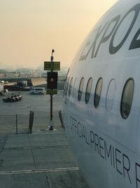 Airplane on airport runway against sky during sunset