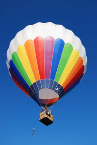 Low angle view of hot air balloon against clear blue sky