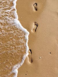 High angle view of footprints on sand at beach