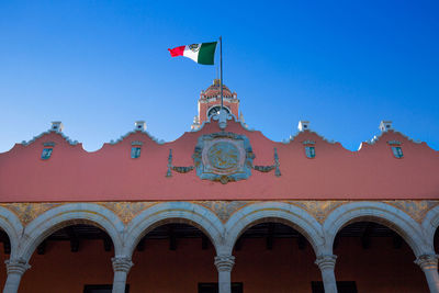 Low angle view of red building against blue sky