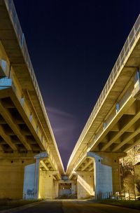 Low angle view of illuminated highway against night sky