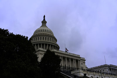 View of the senate capitol building during cloudy day, american flag half mast, washington dc, usa