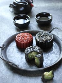 High angle of traditional red and black mooncake on the rough grey texture table.