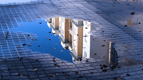 High angle view of buildings by puddle in city