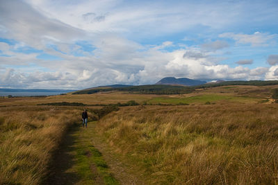 Full length of man walking on field against sky