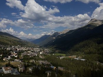 Aerial view of townscape and mountains against sky